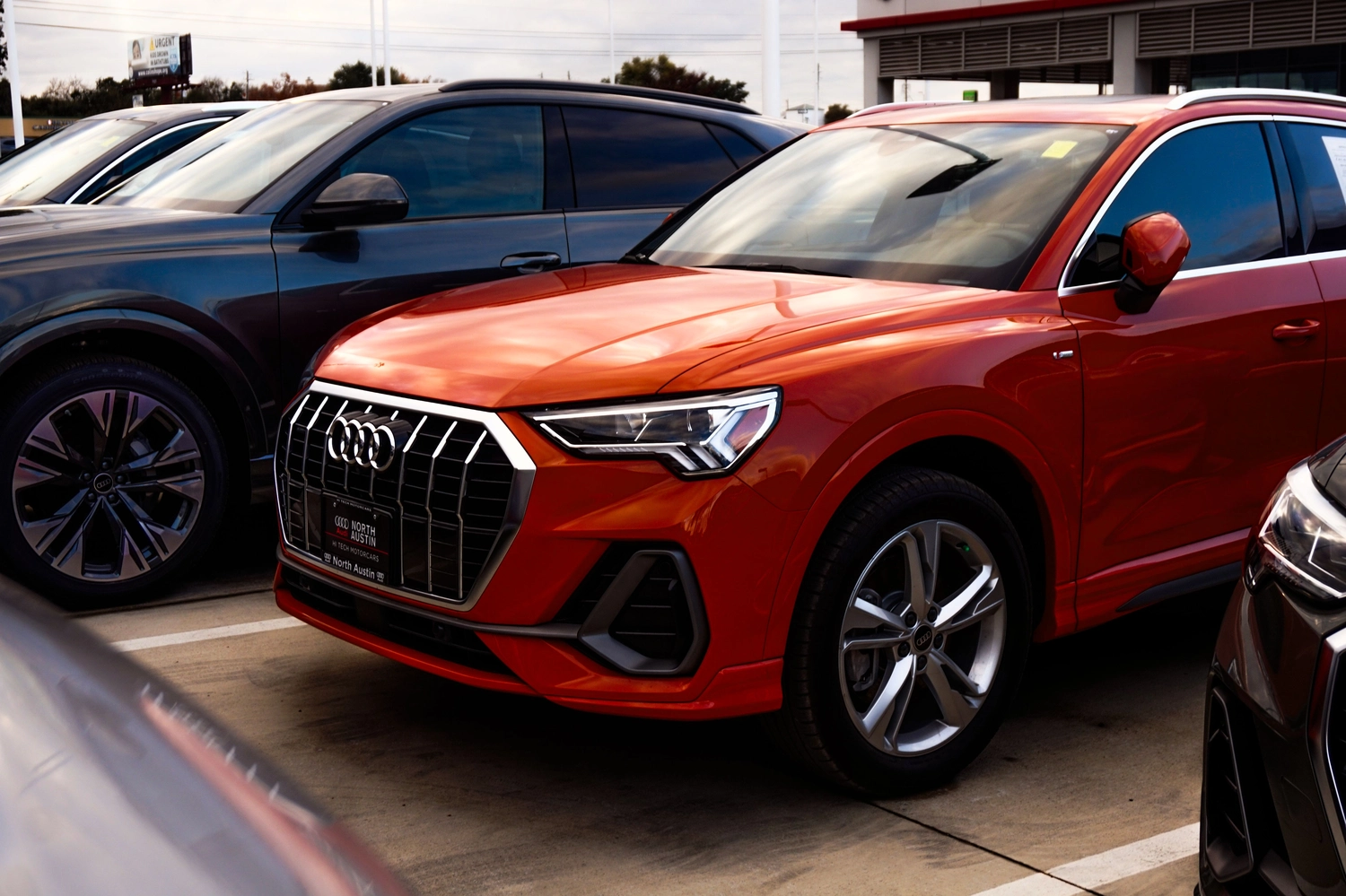 Stern Wagen GmbH - Fahrzeug Einkauf - Ein eleganter roter Audi SUV wird auf dem Gelände eines Autohauses ausgestellt.